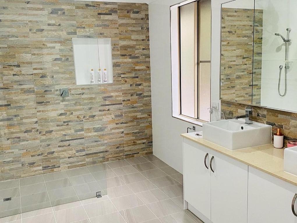 a bathroom with a sink and a tile wall at Sandalwood Downs Fabulous Farm Stay TOODYAY in Toodyay