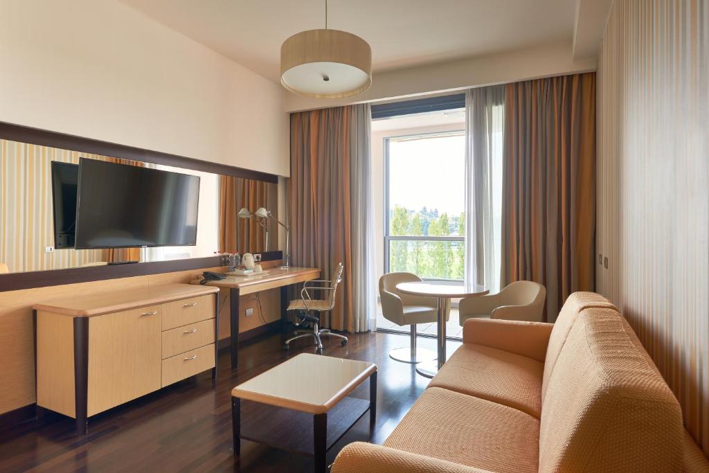 salon z kanapą i stołem z krzesłami w obiekcie UNAHOTELS Varese w mieście Varese