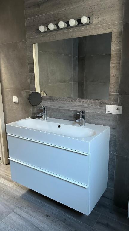 bagno con lavandino bianco e specchio di Casa Polizzi - Maison entière a Fontaine-lʼÉvêque