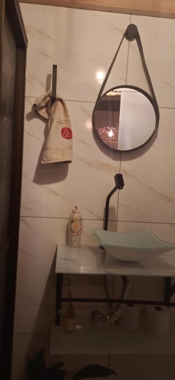 een badkamer met een wastafel en een lamp aan de muur bij Suite na varanda para casais in Foz do Iguaçu