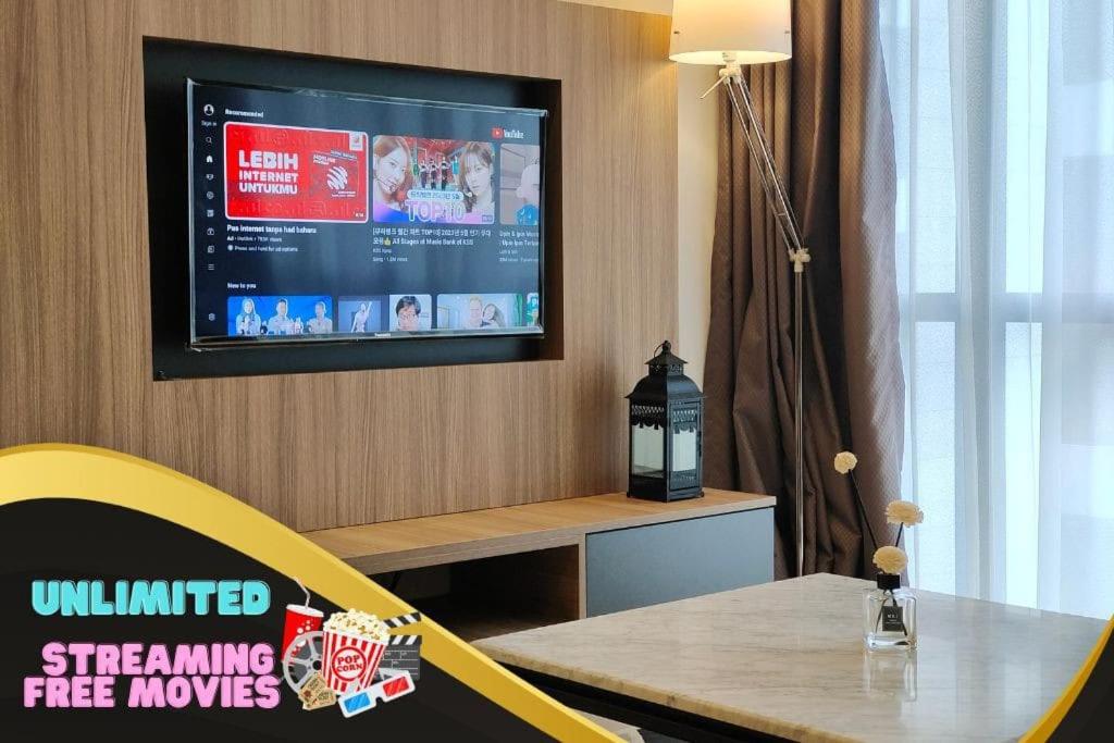 une télévision sur un mur avec une table et une chaise jaune dans l'établissement C2004 Grand Medini Couple 100mbps Netflix By STAY, à Nusajaya