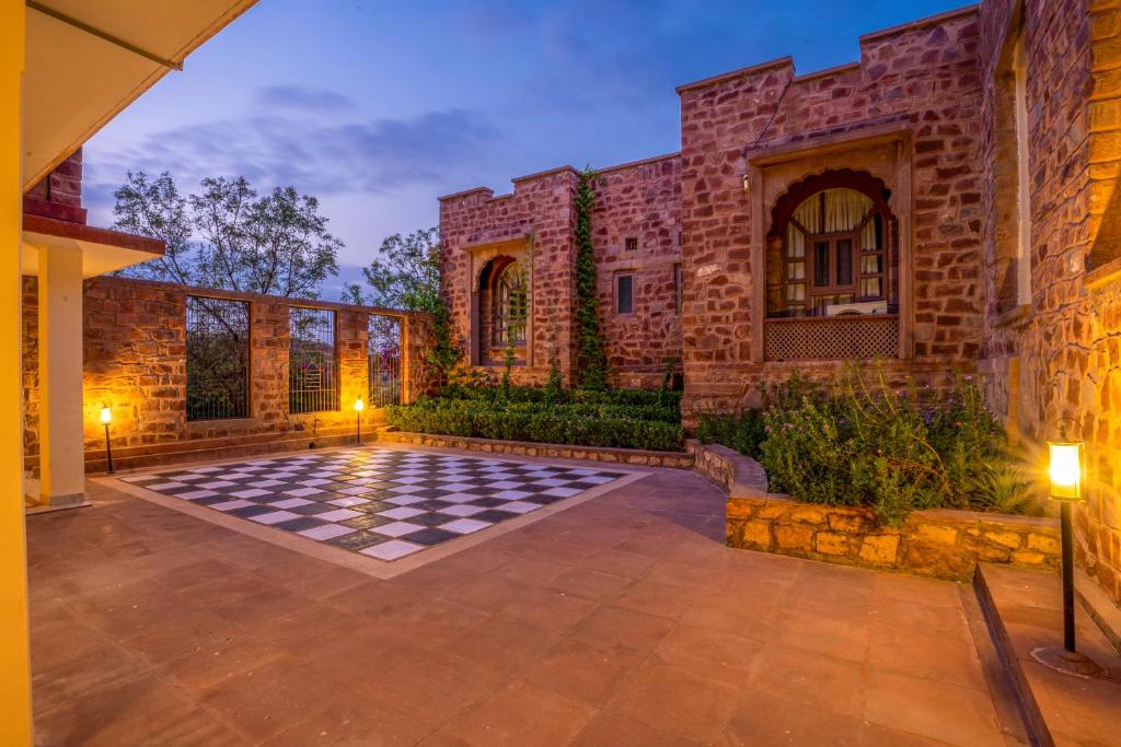 a stone house with a checkered floor in a courtyard at The Hosteller Heritage Palace, Jodhpur in Jodhpur