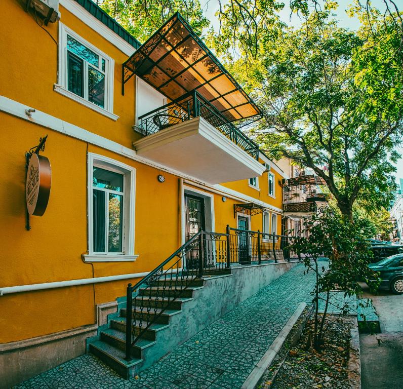 a yellow building with stairs on a street at Hillside City Center Hotel in Baku