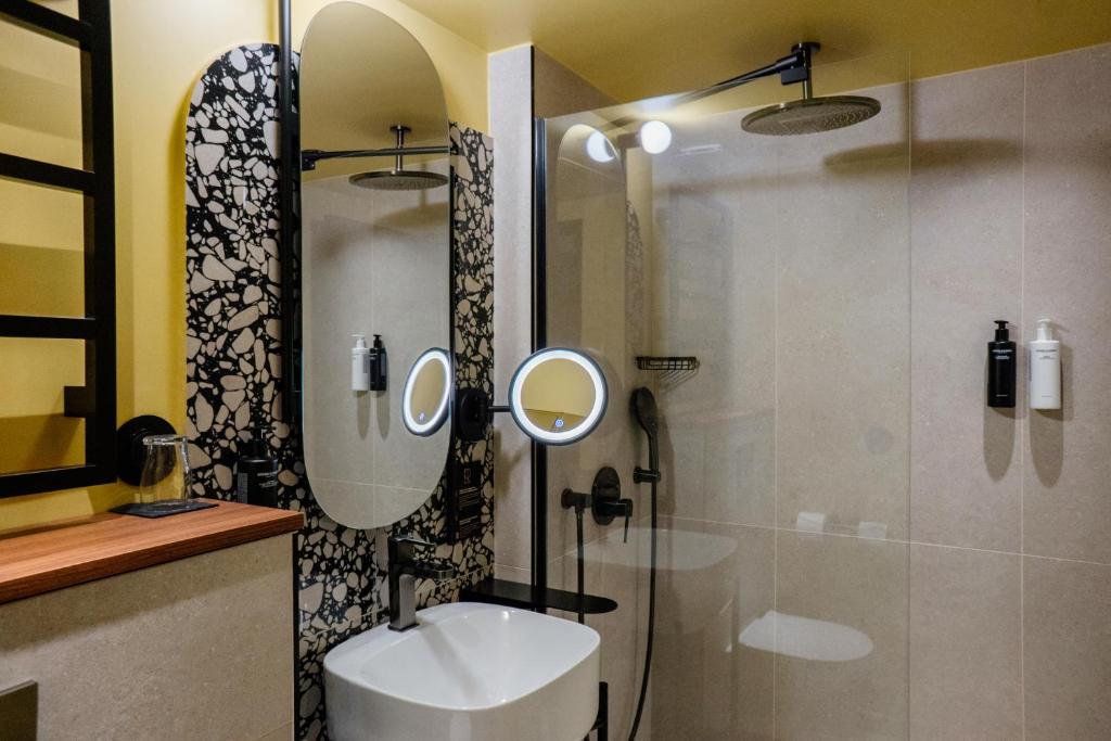 a bathroom with a sink and a shower with a mirror at Hôtel Riesner in Paris