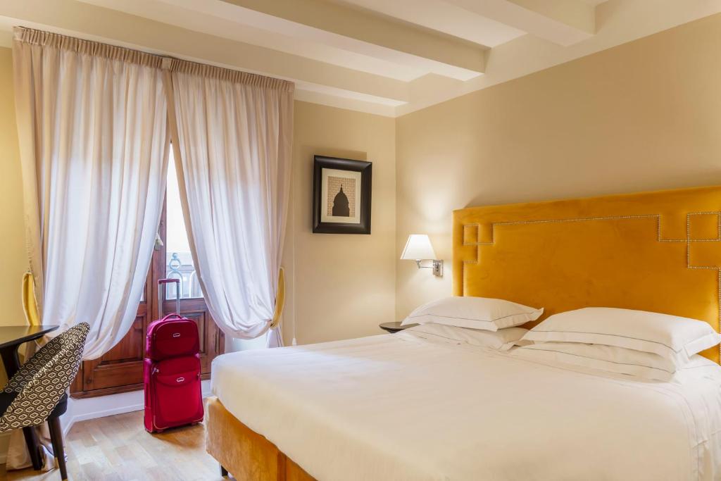 a bedroom with a large bed and a large window at Grand Hotel Cavour in Florence
