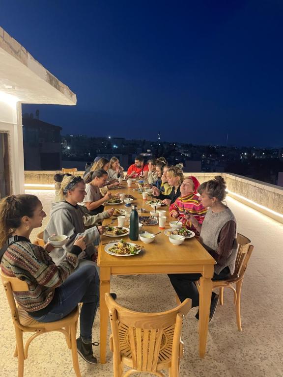 un gruppo di persone sedute a un tavolo su un tetto di Battuta Hostel ad Amman