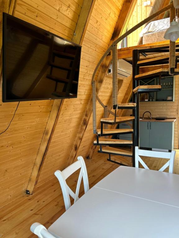 Zimmer mit einem Tisch und 2 Stühlen sowie einem TV in einer Hütte in der Unterkunft HillSide Cottage in K'eda