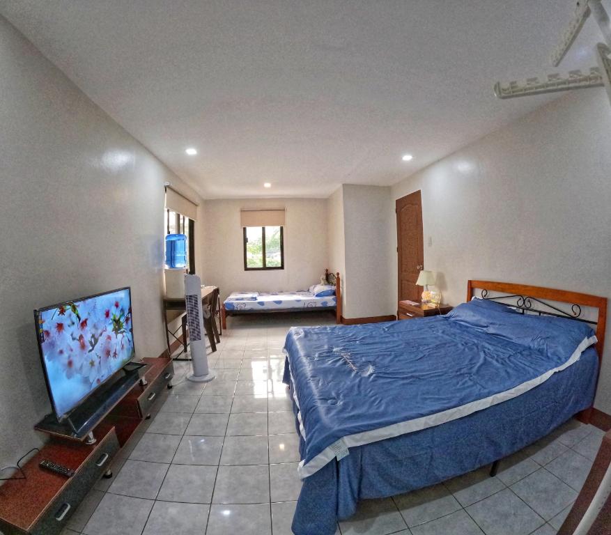 um quarto com uma cama e uma televisão de ecrã plano em Studio Room Casa Loreto near Ayala Center Cebu em Cebu