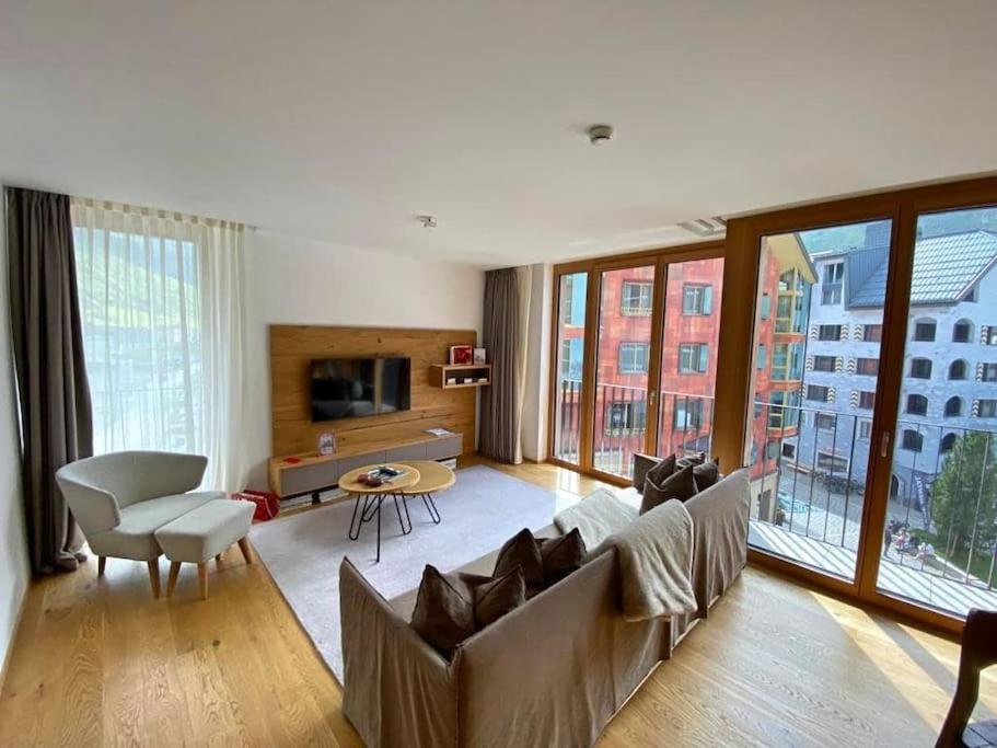 uma sala de estar com um sofá e uma mesa em Luxury Mountain Hotel Apartment em Andermatt