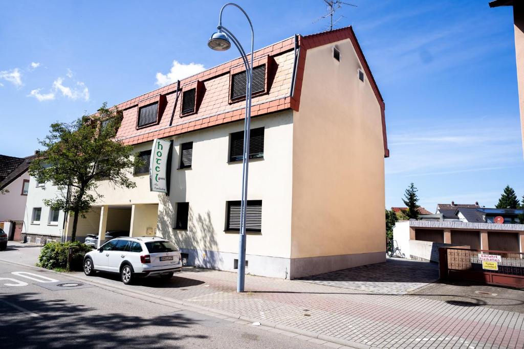 a building with a car parked in front of it at AP Hotel Mannheim Viernheim am Kapellenberg in Viernheim