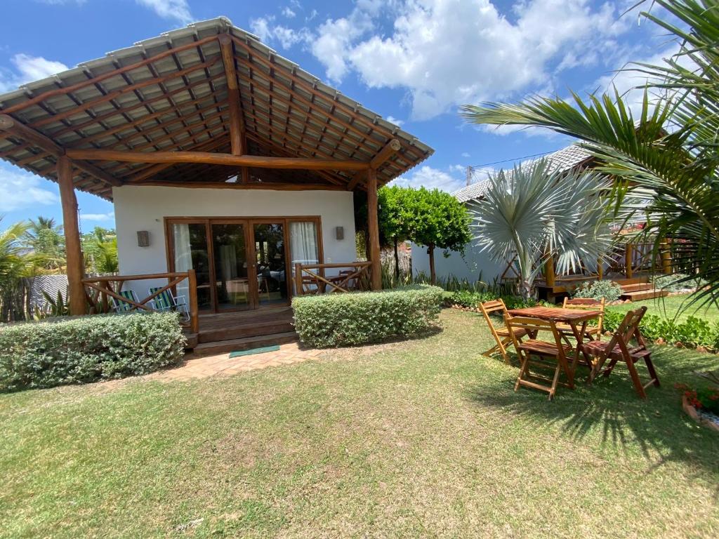 a table and chairs in front of a house at Recanto da Barra Chalé in Barra Grande