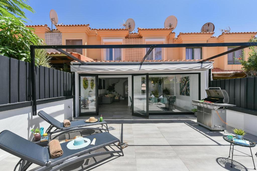 a patio with a table and chairs on a balcony at Duplex Los Tinos II 32 by VillaGranCanaria in Maspalomas