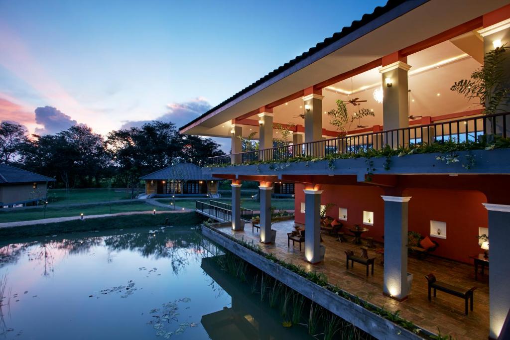 a hotel with a pond in front of it at Seerock The King's Domain in Sigiriya