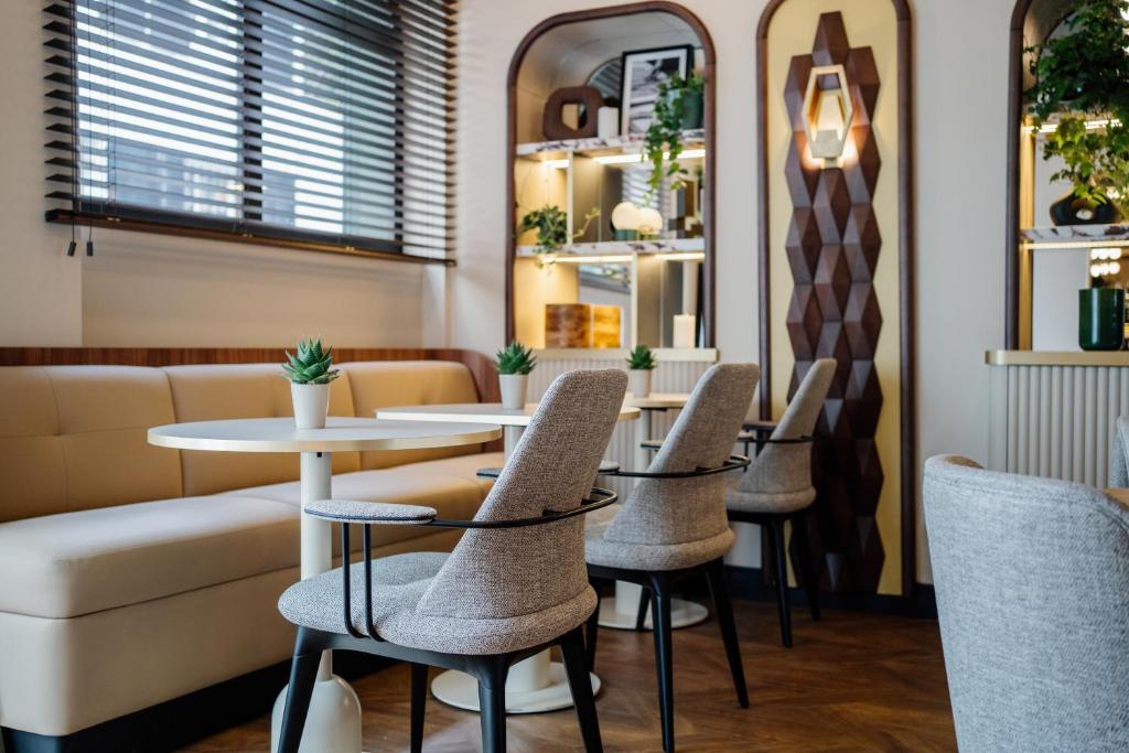 a restaurant with tables and chairs and a couch at Hôtel Riesner in Paris