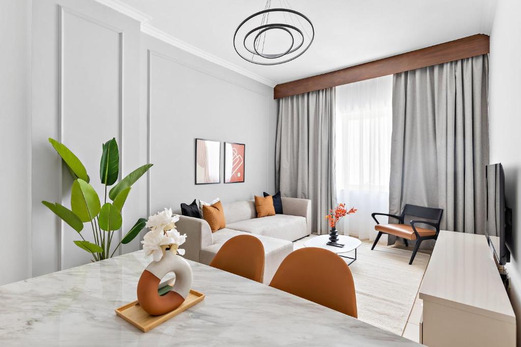 uma sala de estar branca com uma mesa e um sofá em Silkhaus Modern Living Studio in Art Residence no Dubai