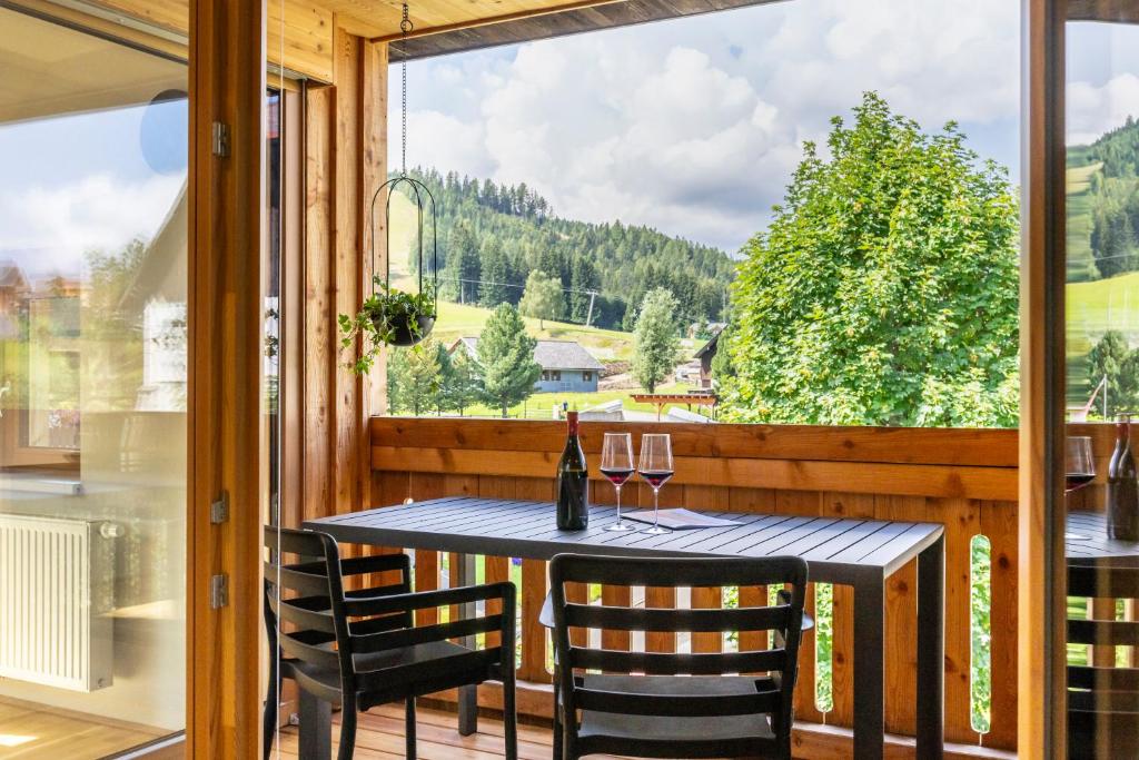 a table and chairs on a balcony with a window at Apartments Am Dorfplatzl in Hohentauern