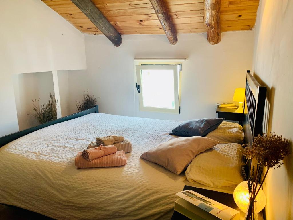 um quarto com uma cama grande com duas almofadas em Casa rústica con encanto en La Puebla de Arenoso em Puebla de Arenoso