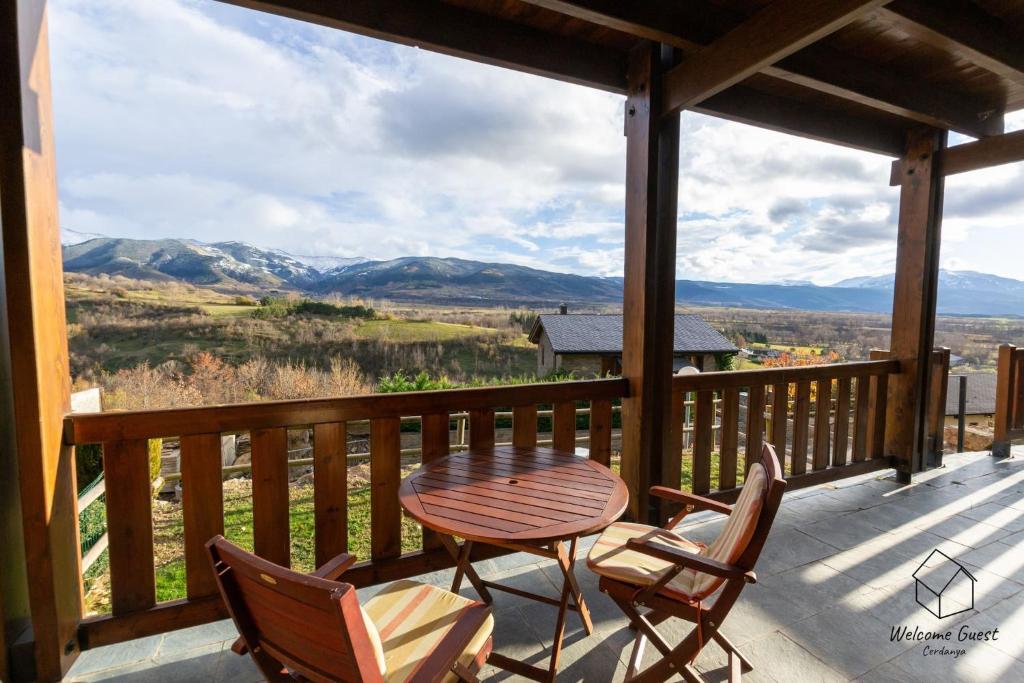 una mesa y sillas en un porche con vistas a las montañas en Apartament la Perdiu en Estavar