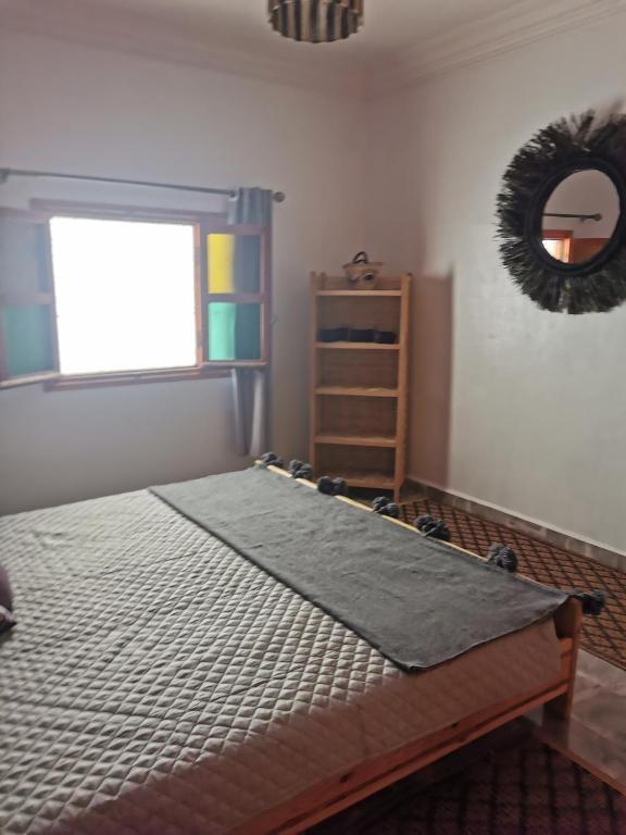 - une chambre avec un lit, une fenêtre et un miroir dans l'établissement Chez Marie, à Al Ghar