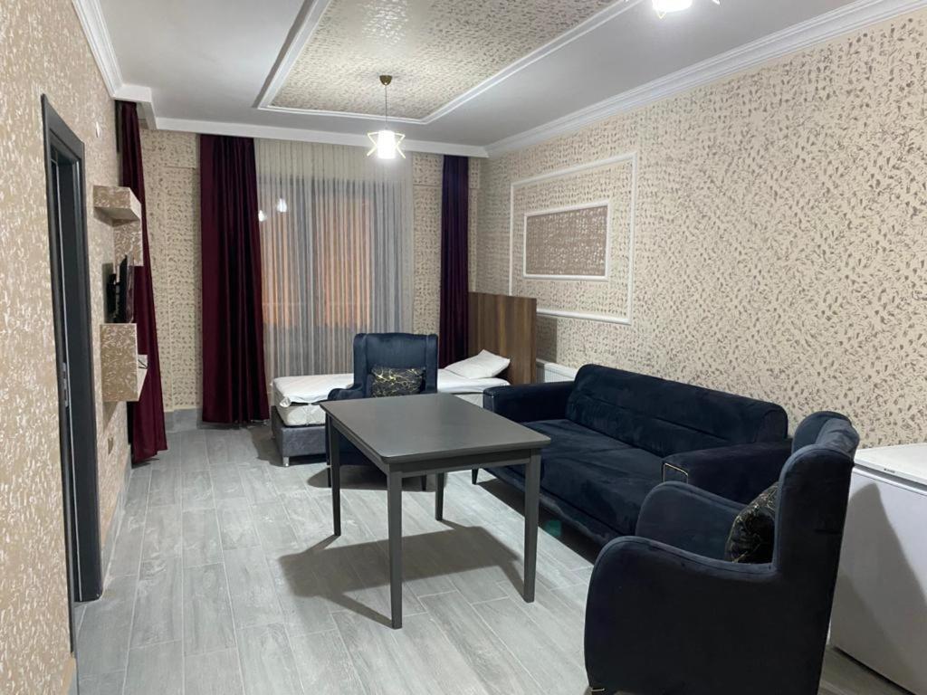 ein Wohnzimmer mit einem Sofa, Stühlen und einem Tisch in der Unterkunft ege suit otel in Bartın
