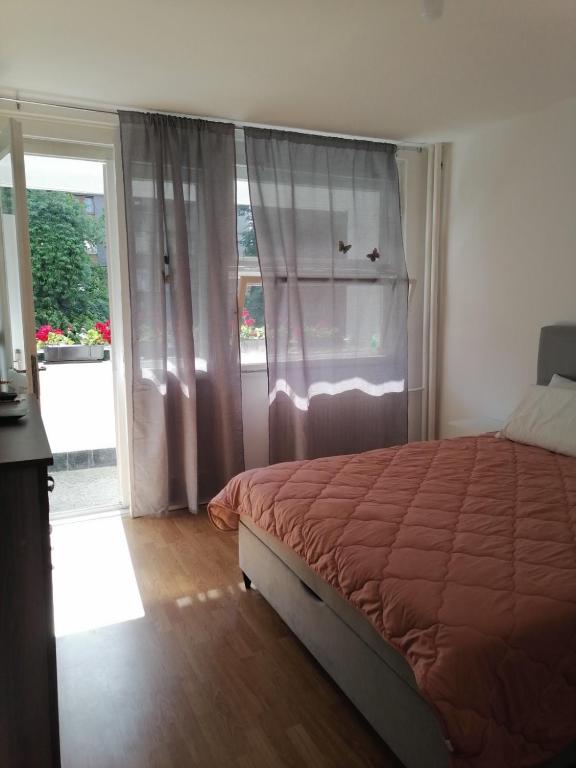 a bedroom with a bed and a sliding glass door at Flowers Apartment Tuzla in Tuzla