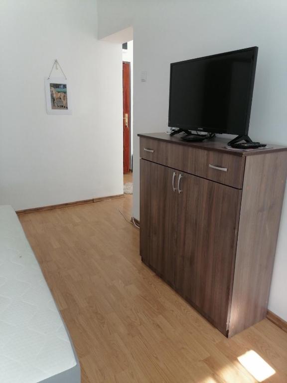 a living room with a flat screen tv on a wooden cabinet at Flowers Apartment Tuzla in Tuzla