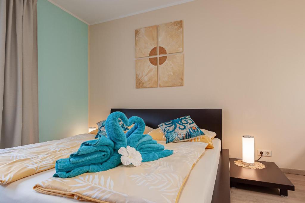 a bed with a blue towel on top of it at Beach Design City Apartment Graz in Graz