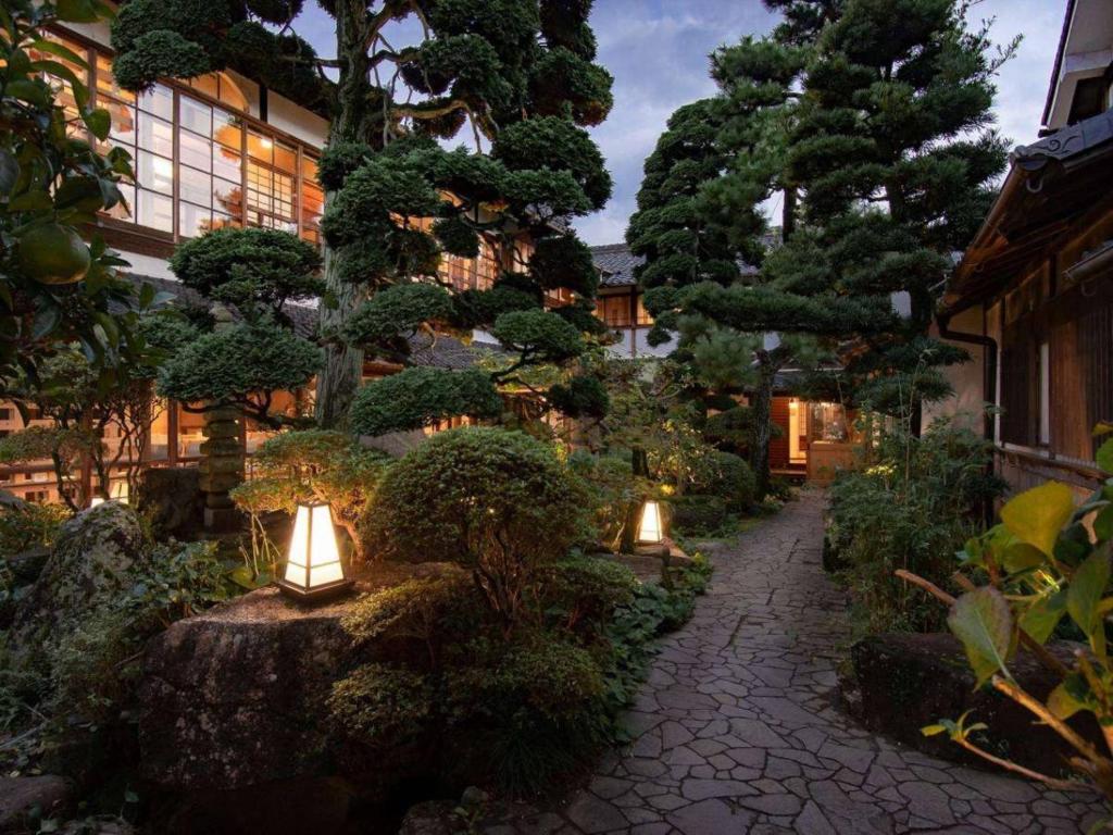 a garden with lights and trees and a building at NIPPONIA HOTEL 伊賀上野 城下町 in Iga