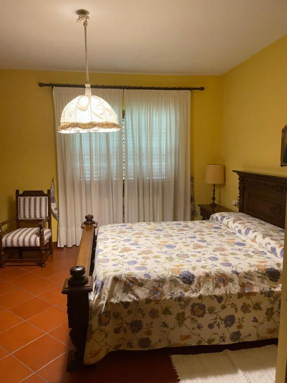 a bedroom with a bed and a chandelier at Le Casacce Case per Vacanze in Carmignano