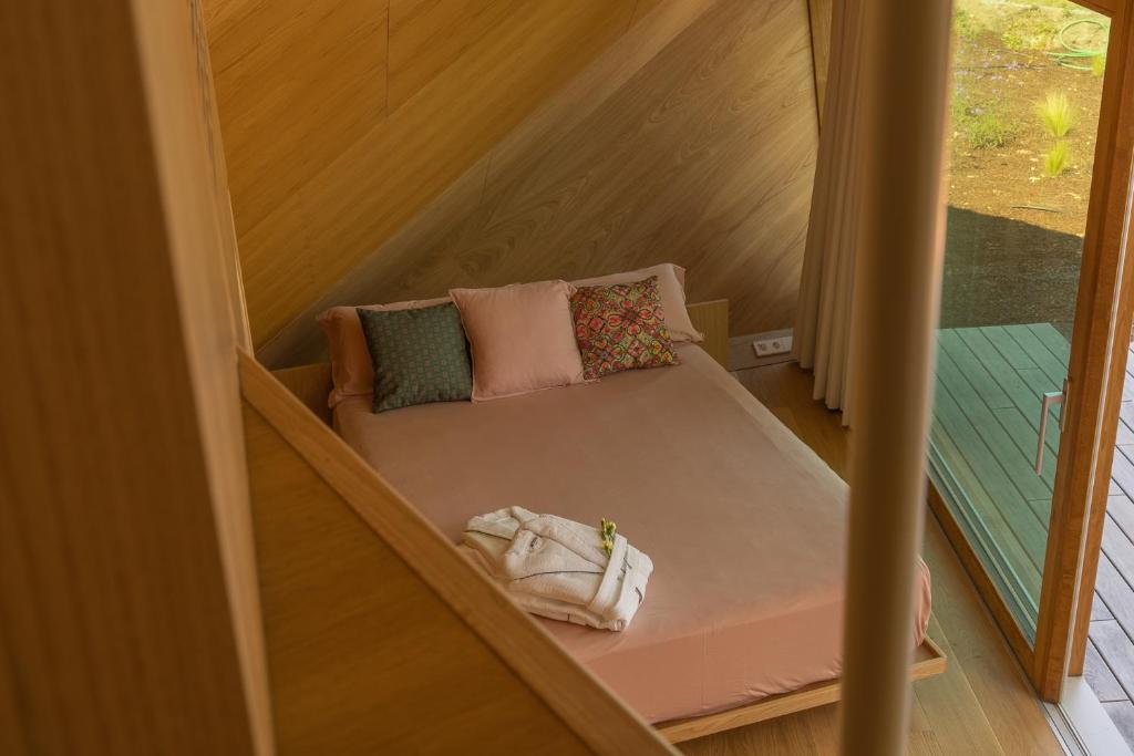 uma pequena cama numa pequena casa com uma janela em Cabañas de Xarás - Margarida em Marín