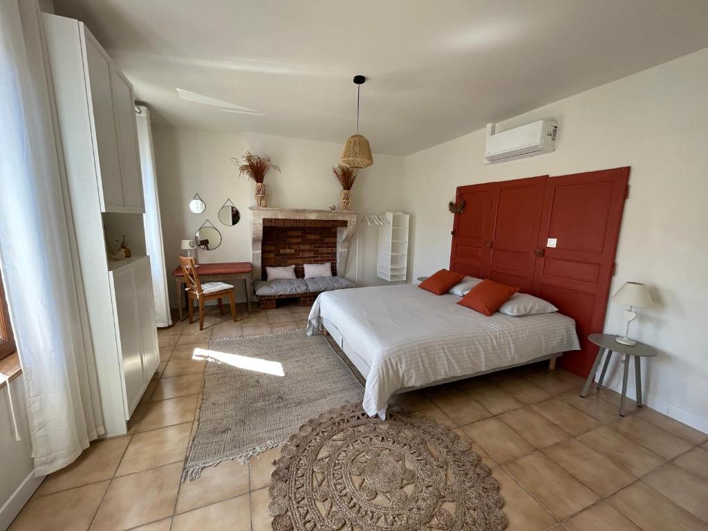 1 dormitorio con 1 cama y chimenea en L'OREE DES LACS, Maison de village tout confort en Radonvilliers