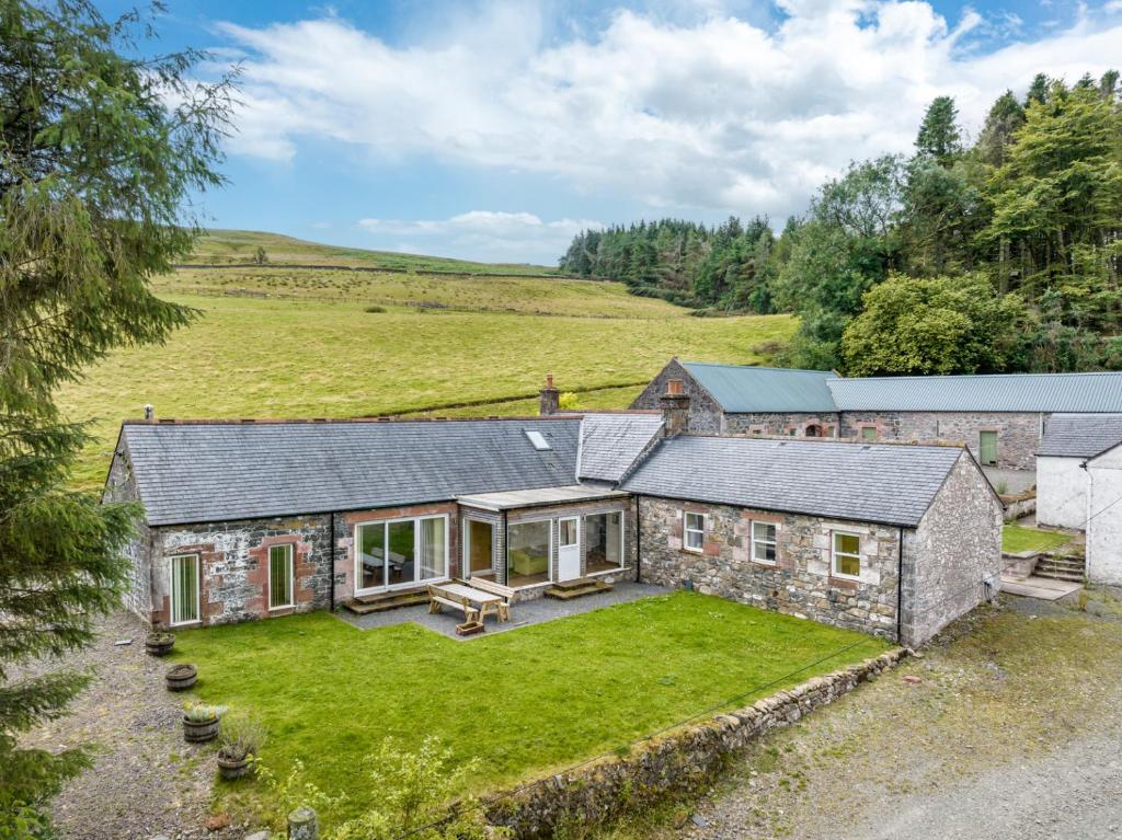 an aerial view of a stone house with a yard at Kilnmark Bothy in Thornhill