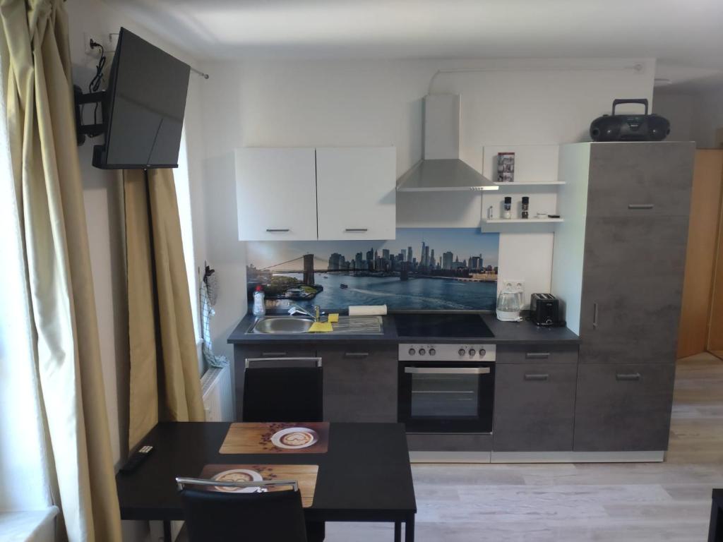 a kitchen with a stove and a table in it at fewo-Grychnik in Dresden