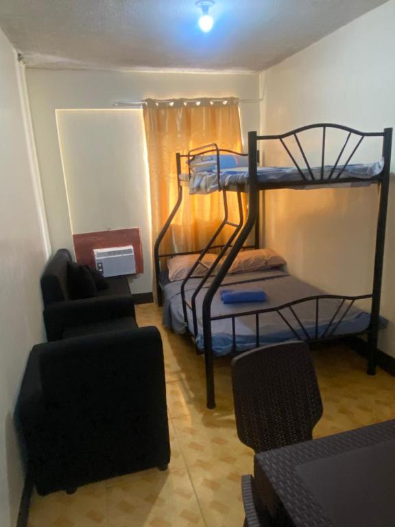 a small room with two bunk beds and a couch at Bagobantay hostel in Manila