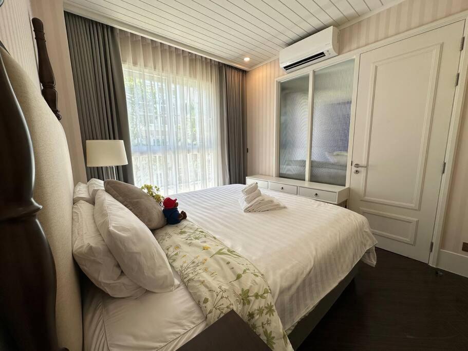 a bedroom with a white bed with a window at Grand Florida Beach Waterpark Condo Resort in Na Jomtien