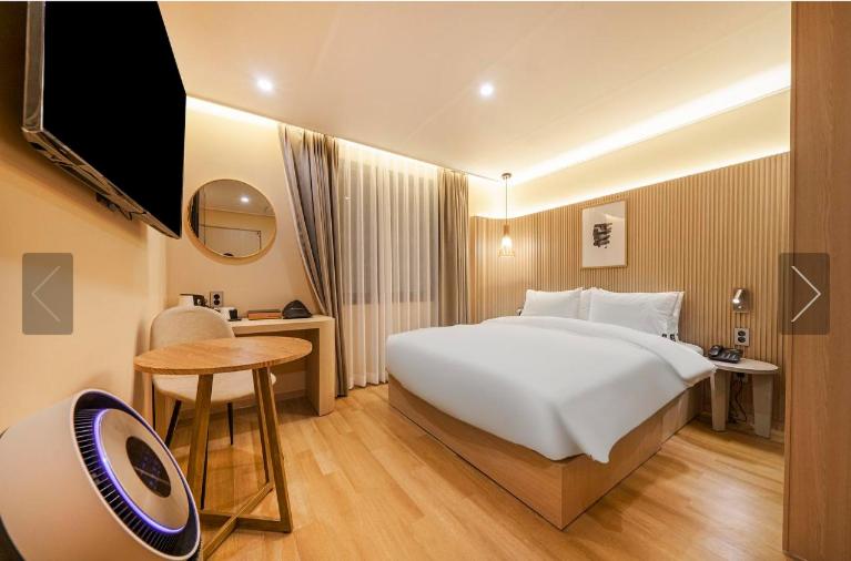 una habitación de hotel con una cama grande y una mesa en Brown Dot Hotel Yeonsan en Busan