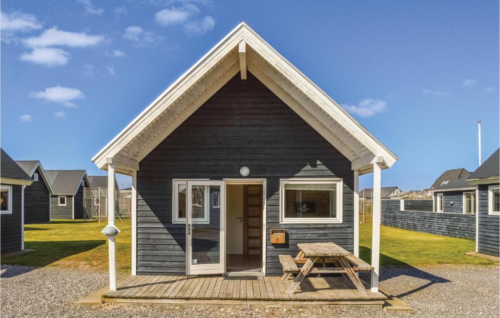 a small black house with a picnic table in front of it at Hytte 12 in Thyborøn