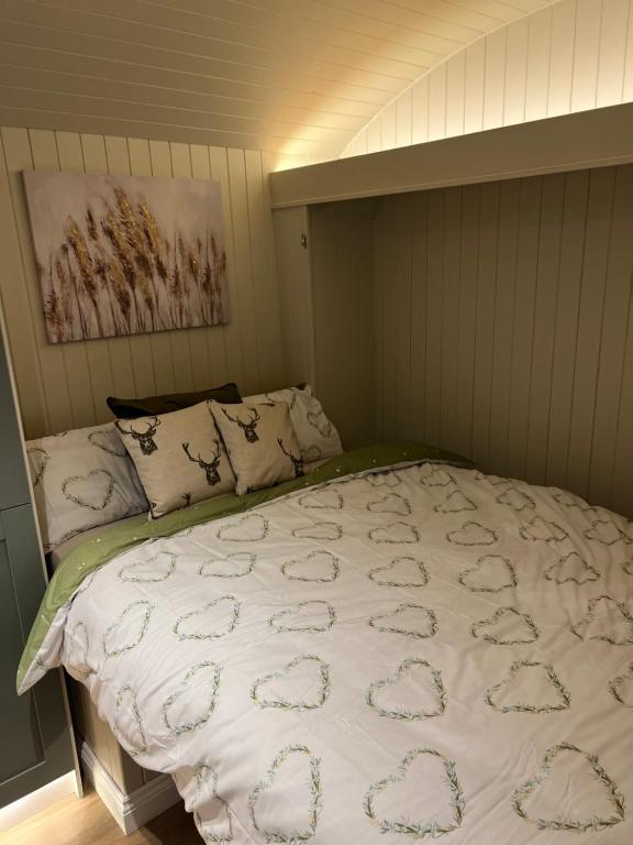 a bed with a white comforter in a bedroom at Bodos’ Shepards Hut in Durham
