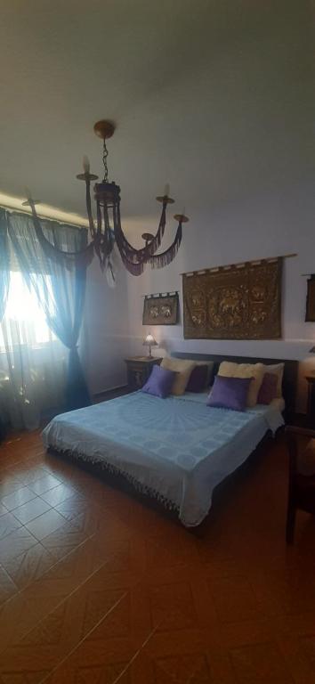 a bedroom with a bed and a chandelier at La stanza di Vema in Massarosa