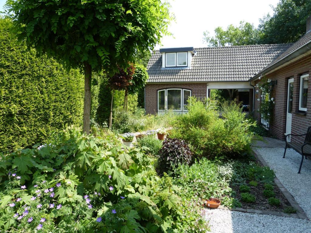 un jardín con flores y plantas frente a una casa en B&B Oostrik en Leende