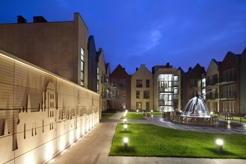 a campus at night with buildings and a fountain at Apartamenty Szeroka - Old Town Holidays Home in Gdańsk