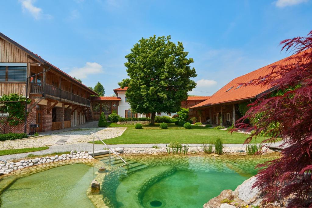 ein Haus mit einem Teich im Hof in der Unterkunft Neulendtnerhof in Mettmach