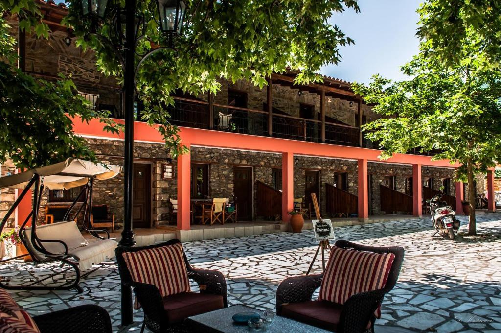 a courtyard with two chairs and a building at Guesthouse Kalypso in Kokkino Nero