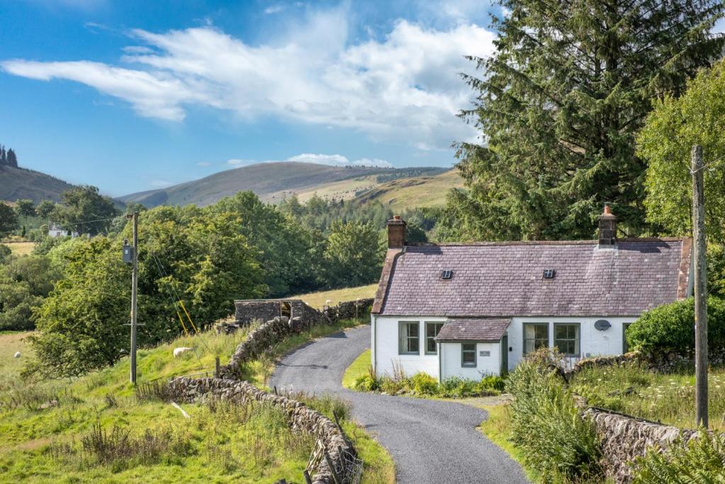 a cottage on a road in the hills at High Auchenbrack in Thornhill