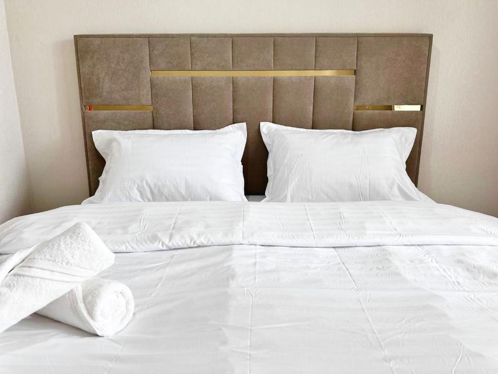 TaldykolʼにあるKorkem 5 apartmentsの白いシーツと枕が備わる大きな白いベッド