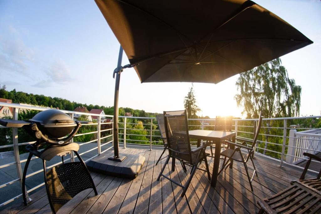a patio with an umbrella and a table and chairs at Weitblick-Loft mit Terrasse in Rostock