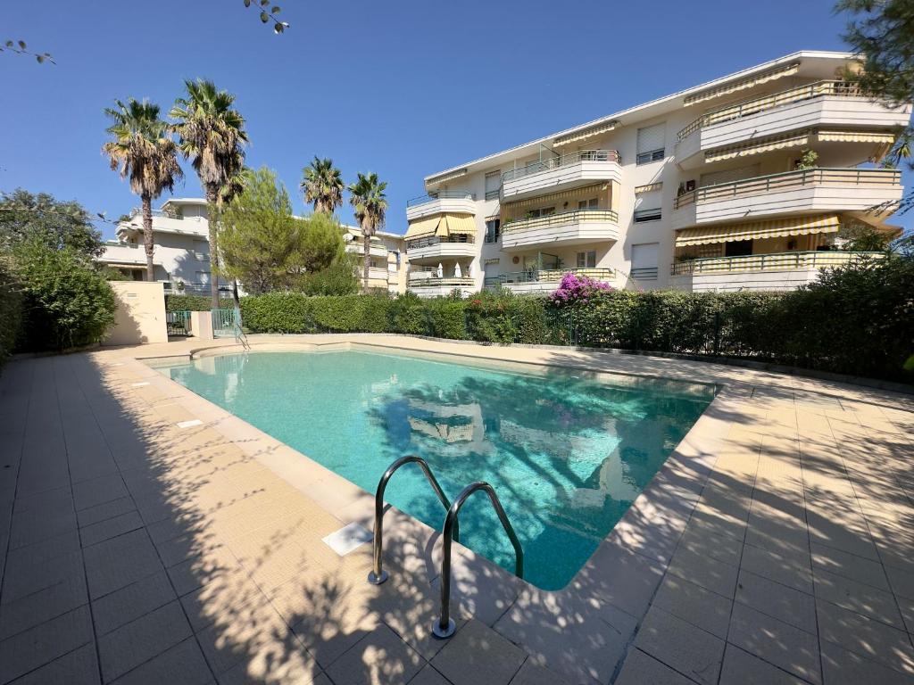 una piscina di fronte a un edificio di Regent Côte d'Azur air-conditioned, pool, garden & parking a Villeneuve-Loubet