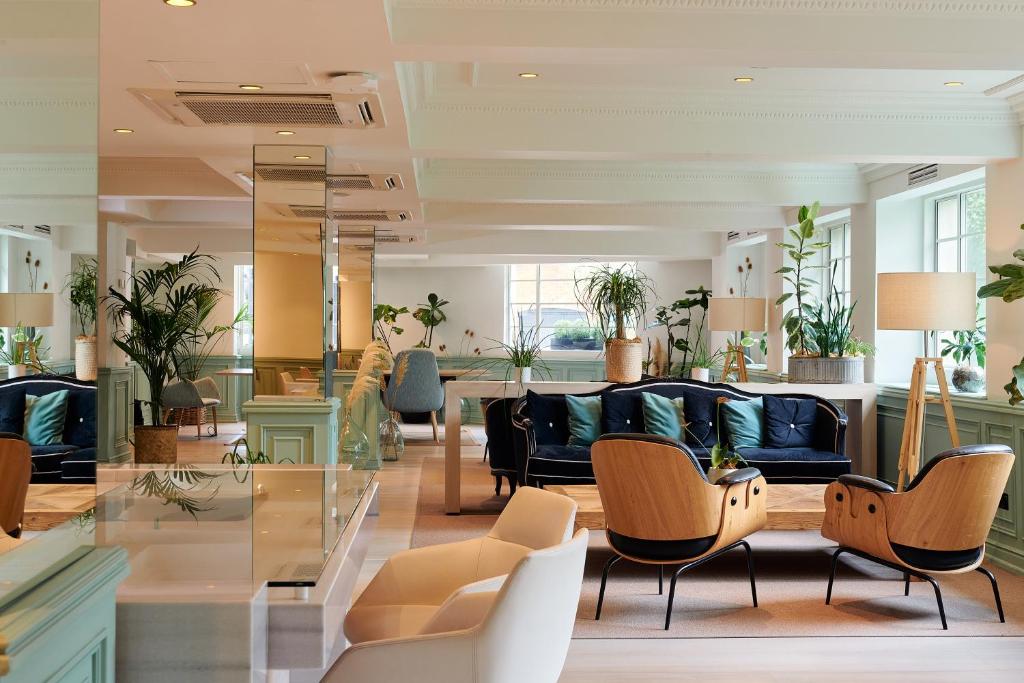 a lobby with a blue couch and chairs at The Level at Melia White House in London