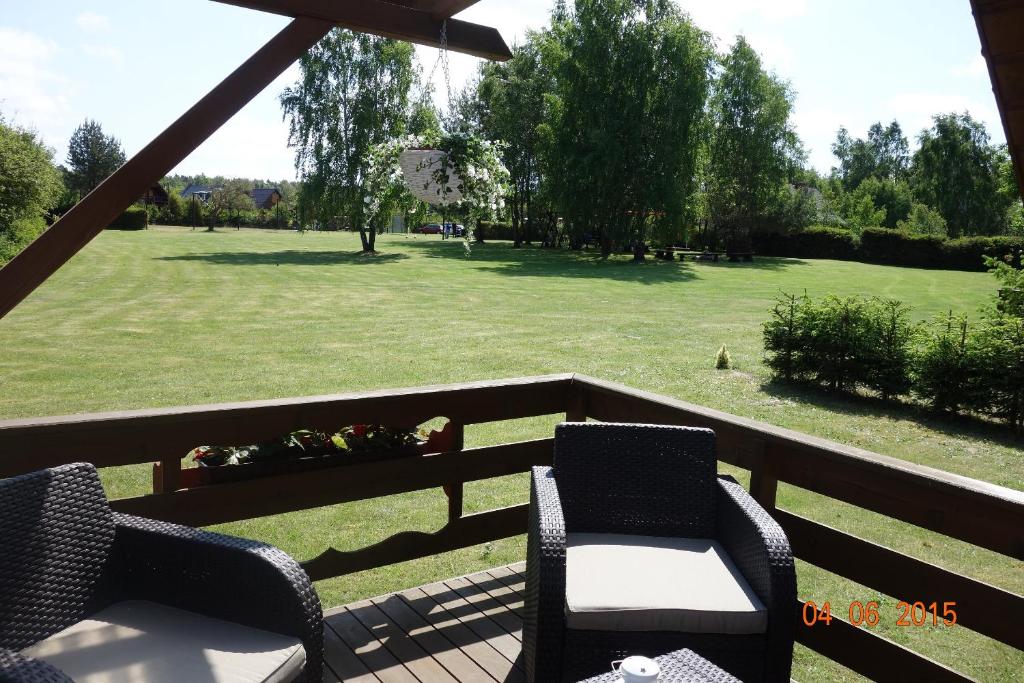 a porch with two chairs and a field of grass at Domki Victoria in Sasino