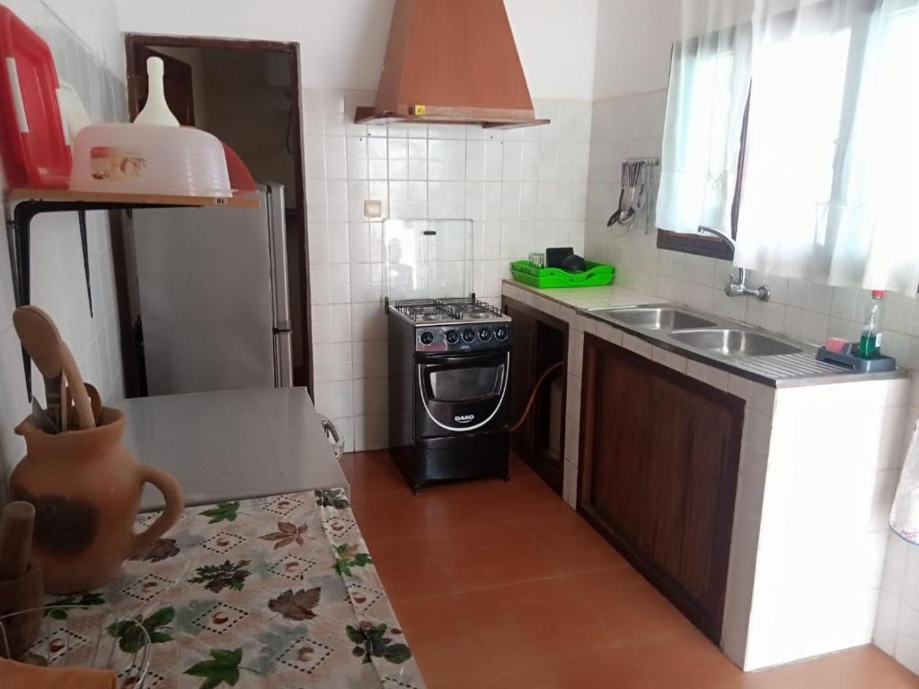 uma pequena cozinha com um fogão e um lavatório em Landa's Guest House em Praia do Tofo